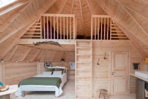 a bedroom in a wooden cabin with a bed in it at kotaventure Famille in Le Mesnil-Villement