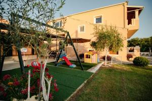 a yard with a playground in front of a house at Al Mare Family Suite in Mólos