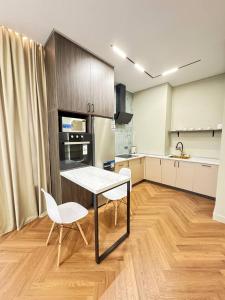 una cucina con tavolo e due sedie in una stanza di Центр города 2 room meridian apartments super new modern a Almaty