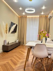 una sala da pranzo con un tavolo bianco e sedie bianche di Центр города 2 room meridian apartments super new modern a Almaty