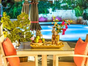 a table with a tray of fruit and a vase of flowers at Kalkan Suite 102 in Kas