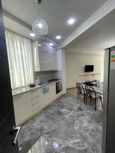 una cocina grande con mesa y sillas. en Gldani, en Itʼkhvisi