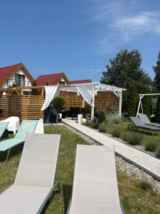 a backyard with two benches and a house at Willa La mer-Balia z jacuzzi, sauna ,klimatyzacja ,rowery in Ustka