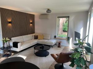a living room with a couch and a table at Forest house with sauna in Norg