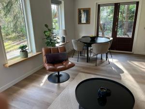 a living room with a table and a chair at Forest house with sauna in Norg