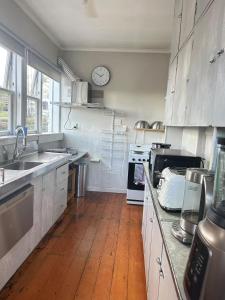 a kitchen with wooden floors and a clock on the wall at Parnell City Haven Same Price for 1 to 6 Guests Villa with Full Kitchen in Auckland