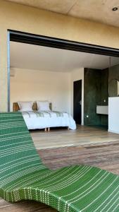 una camera da letto con un letto e un divano verde di Les chambres Toussaint a Pianottoli-Caldarello