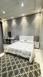 a bedroom with a large bed and a wall with patterns at شاليه ريف المملكة in Hail