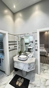 a bathroom with a sink and a mirror at شاليه ريف المملكة in Hail +3 photos