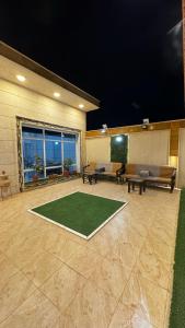 a living room with a green rug on the floor at شاليه ريف المملكة in Hail
