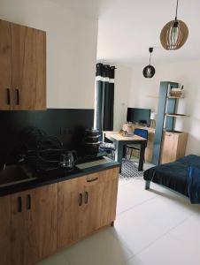 a kitchen with wooden cabinets and a living room at Dom Gościnny Helios in Mielno