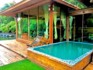 a house with a swimming pool on a deck at Kodaun River Kwai Resort in Kanchanaburi City