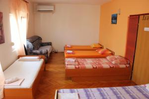 a room with three beds and a couch at Azizam hostel in Split