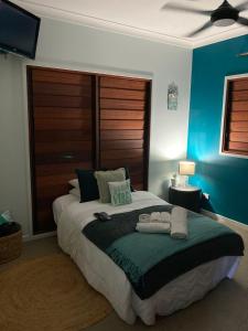 a bedroom with a large bed with two towels on it at Isle views Newell Beach 15min to Port Douglas in Newell Beach