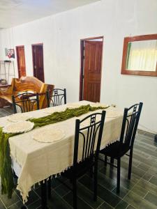 a dining room table with chairs and a table with a tablecloth at Cockatoo Room Rentals Siquijor in Siquijor