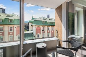 a balcony with chairs and a view of buildings at Soukromý Apartmán PVV Pec in Pec pod Sněžkou +12 photos