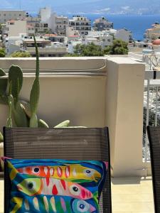 a chair with a pillow on a balcony with a cactus at 30 Thirty in Agios Nikolaos