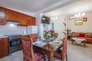 a kitchen and living room with a wooden table and chairs at Alexandros Apt in Doukádes