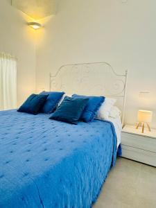 a blue bed with blue pillows in a bedroom at Simone's House in Tuglie