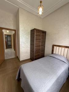 Un dormitorio con una cama grande y una lámpara de araña. en Appartement Tanger NAKHIL BOUGHAZ 2 Premium CAN 2025, en Tánger