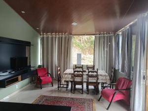 a dining room with a table and red chairs at Casa da Pedra in Pedra Azul