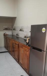 a kitchen with a stainless steel refrigerator and wooden cabinets at Yarl Nest in Jaffna