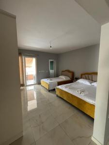 a bedroom with two beds and a large window at Blissful Apartments in Sarandë