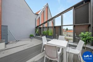 balcone con tavolo e sedie bianchi di LOFT 1&2 - Grano Residence a Danzica
