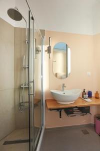 a bathroom with a sink and a glass shower at Hermosa Seaside Living in Ermoupoli