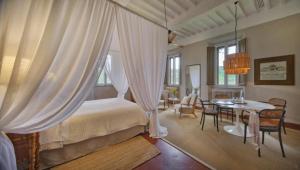 a bedroom with a bed and a table and chairs at La Pescaia Resort in La Pescaia