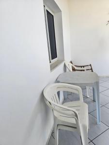 a white table and chairs in a room with a window at Casa blu ghar el melh in Île Pilau +21 photos