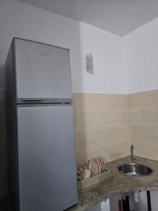 a refrigerator in a kitchen next to a sink at Casa blu ghar el melh in Île Pilau