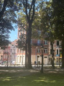 a park with trees in front of a building at Studio Lilia in Brussels