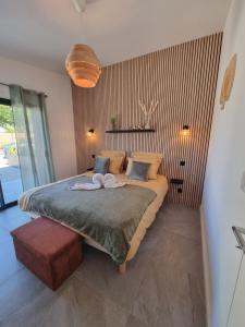 a bedroom with a large bed with two towels on it at Gîtes Les Rozens, créés pour vous détendre et vous offrir une parenthèse de bonheur! in Plérin