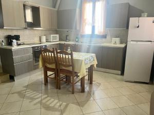 a kitchen with a table and chairs and a refrigerator at Kampos Apartment in Chios