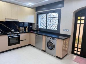 a kitchen with a washing machine and a window at Villa de luxe Océan Asilah in Asilah