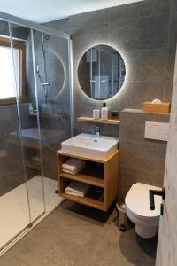 a bathroom with a sink and a shower and a toilet at Hotel Les Chamois in Verbier