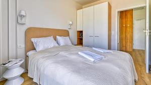 a bedroom with a large bed with two towels on it at Rezydencja Niechorze D210 z 2 sypialniami Eco Boho - 5D Apartments in Niechorze