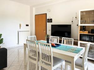 Una cocina y un comedor con mesa y sillas. en Holihome Olympia, en Alba Adriatica