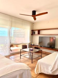 a living room with a flat screen tv and a table at Azul Calma in Vinarós