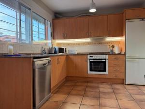 a kitchen with wooden cabinets and stainless steel appliances at Azul Calma in Vinarós