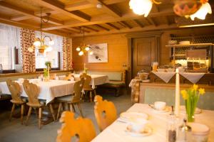 a restaurant with tables and chairs in a room at Pension Daniel in Lech am Arlberg