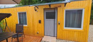 a small yellow building with a door and a table at Ferienwohnung Viona in Neustrelitz