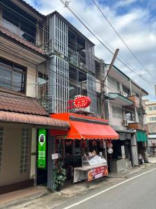 a store with a red awning in front of a building at 333 MiNi House in Chiang Mai