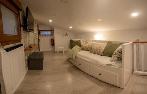 a living room with a white couch and a television at SERENA Apartamento Cudillero in Cudillero