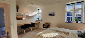 a bedroom with a bed and a desk and chairs at Stjernebo in Nørre Snede