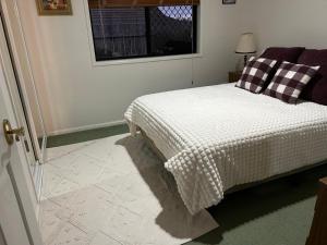 a bedroom with a bed with a checkered blanket at Orchid House Shared in Stanthorpe