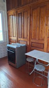 a kitchen with a stove and a table with two chairs at სახლი ბუნებაში House in nature in Tsikhisdziri +86 photos