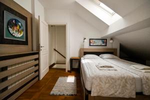 ein Schlafzimmer mit einem großen Bett und einem Dachfenster in der Unterkunft Green and Blue Garden Apartments in Belgrad