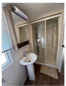 a bathroom with a sink and a shower at Platinum 3 Bedroom Caravan, Wifi, Parking, Seaview, in Budleigh Salterton +6 photos